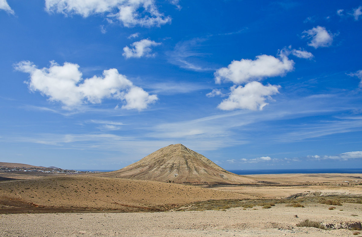 Der Berg Montaña de Tindaya liegt im Nordwesten der Insel. Für die Ureinwohner der Insel war Tindaya ein heiliger Ort, dem Zauberkräfte zugeschrieben wurden. Der 400 Meter hohe Berg, der durch den Lauf der Zeit eine ganz eigene Form bekam, ragt einsam aus der flachen, trockenen Landschaft Fuerteventuras heraus.
Aufnahme: 19. Oktober 2017