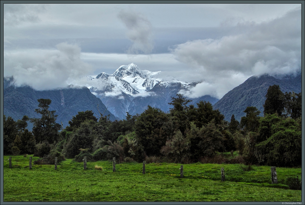 Der Mount Tasman ist mit 3.498 m der zweithöchste Berg Neuseelands. Am 23.10.2016 geben die Wolken bei Fox Glacier kurz den Blick auf den Berg frei, während der unmittelbar rechts befindliche Mount Cook - der höchste Berg Neuseelands - sich hinter einem Wolkenschleier versteckt.