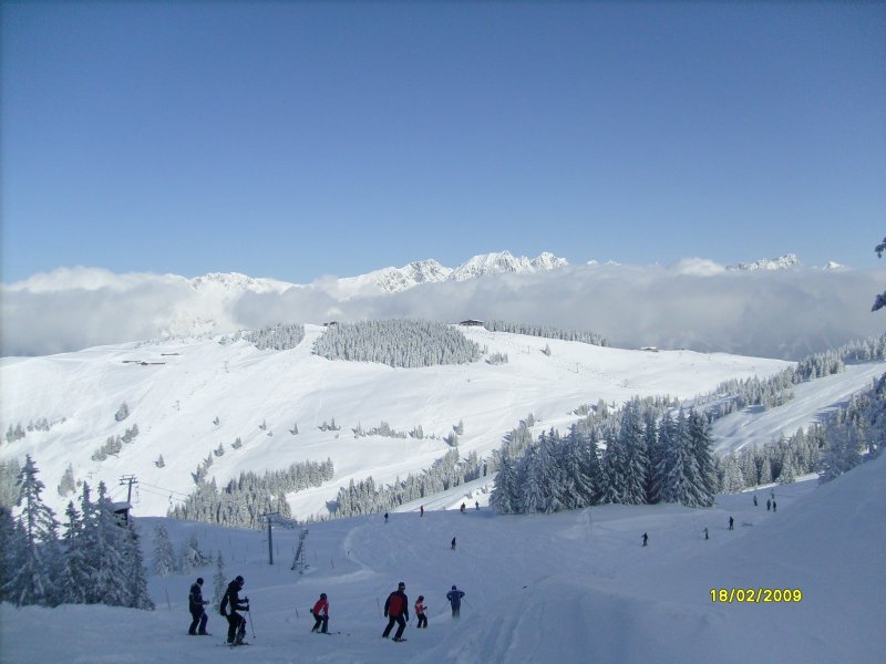 Blick auf die verschneite Bergwelt der Tiroler Alpen in Richtung Scheffau / Ellmau im Skigebiet Wilder Kaiser. 