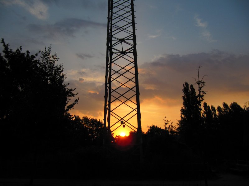 Die morgendliche Sonne blinzelt durch einen Strommast am Charlottenburger Verbindungskanal in Berlin-Charlottenburg. August 2009