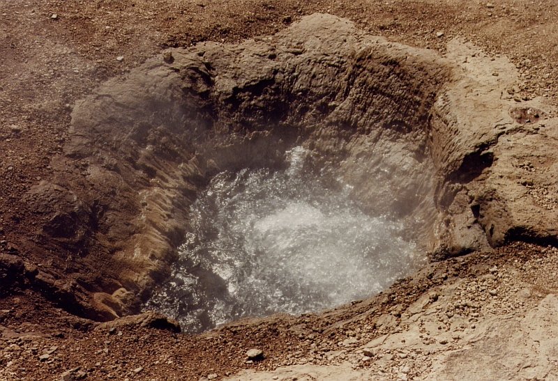 Geysir Strokkur (dt.Butterfass) ca. 70 km stlich von Reykjavik im Juni 1997. Nach einen Ausbruch sieht man erst einmal nichts, dann steigt Wasser hoch, verschwindet wieder, das passiert ein paar Mal, das Wasser steigt dabei jedes Mal etwas hher. Unter Beachtung der Windrichtung kann man recht nahe heran gehen.
