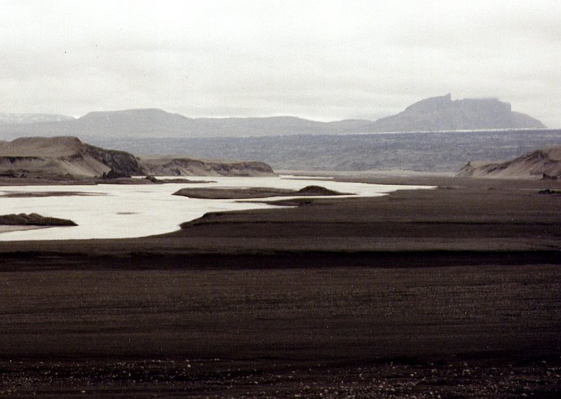 Gletscher-Flu Nupsvtn im westlichen Teil des Skeidararsandurs im Juni 1997, dahinter der Skeidararjkull (Gletscher), darber die Skaftafellstjll (Berge). In dieser Gegend mte der 450 m hohe Gletschersee durchgebrochen sein, auf der Satelittenkarte ist recht gut der Gletschereinbruch bis zum 45 km entfernten Vulkan Grimsvtn zu sehen.