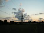 Abendhimmel mit Wolken und Hochspannungsmast im Mnsterland am 19.06.2004.