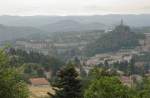 Teil der Stadt Le-Puy-en-Velay im Massif Central am 26.07.2009. Rechts der Vulkankegel Rocher Corneille mit der Statue der Notre-Dame de la France von 1860