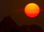 Der Sonnenaufgang wird von einer Krähe beobachtet, die auf einem Schornstein sitzt. - 01.08.2014
