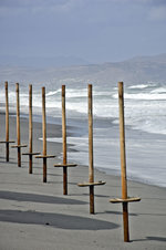 Sonnenschirm-Pfosten am Strand vor Geranie auf Kreta.