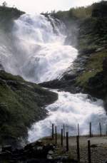 Norwegen, Aurland: Der Wasserfall Kjosfossen befindet sich 840 Meter über dem Meeresspiegel und hat eine Fallhöhe von 93 Metern. Der Wasserfall ist nur mit der Bahn (Flåmsbanen Myrdal - Flåm) erreichbar. Aufnahmedatum: 4. August 1982.