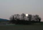 Whrend im Osten die Sonne aufgeht, verabschiedet sich im Westen der Mond. Bei Arnex, im Waadtlnder Jura am 23. Januar 2008.