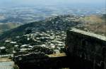 Blick ber das unterhalb der Kreuzritterburg Crac des Chevaliers liegende Dorf auf die Ebene am Fu des Alawitengebirges in Syrien (Dia vom Mai 1989).