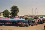 Fischland-Dar� Der Zingster Kanalhafen, eingf�gt in eine einzigartige Boddenlandschat. Zu DDR-Zeiten und auch davor, einst ein einfacher Fischereihafen, so ist dieser heute ganz vom Tourismus gezeichnet. Sehr gut ausgebaut, auch wasserseitig. Die 'Parade' der Schirme �bersteigt fast die kleine Wasserfl�che. Wer hier hungert oder verdurstet, dem ist ncht mehr zu helfen ... ein Paradis f�r alle Fischfreunde !! Die Schiffe der 'Wei�en Flotte' vert�uen sich aber nur wasserseitig. Foto: August 2007