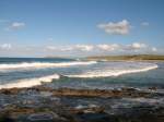 Nordk�ste, Klippen Welle um Welle rauscht an den Strand bei Portrush.
(September 2007)