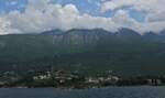 Wolken kleben an den hohen Bergrcken am Gardasee.