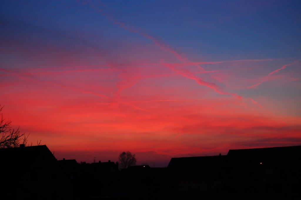 Abendrot mit Kondensstreifen und der Silhouette der Huser am 27. Mrz 2012 in Birkenfeld. Die Farben wurden brigens NICHT nachtrglich bearbeitet.