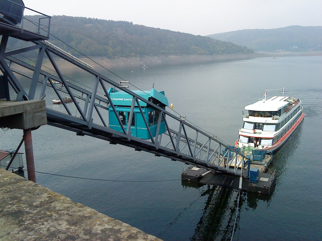 An der Edertalsperrmauer West ist eine Personenkabinenseilbahn neu gebaut worden, die den Fahrgsten, insbesondere Senioren, Rollstuhlfahrern und Behinderten, einen stufenlosen und bequemen Zugang zu den Fahrgastschiffen ermglicht. Diese Anlage ist bis zu einer Neigung von 8 als normale Steganlage zu nutzen. Bei strkerer Neigung fhrt die Kabine der Seilbahn vom Ufer zum Schiff oder umgekehrt. Hier ein Fahrgastschiff am Anleger. Aufgenommen im 20.09. 2009.