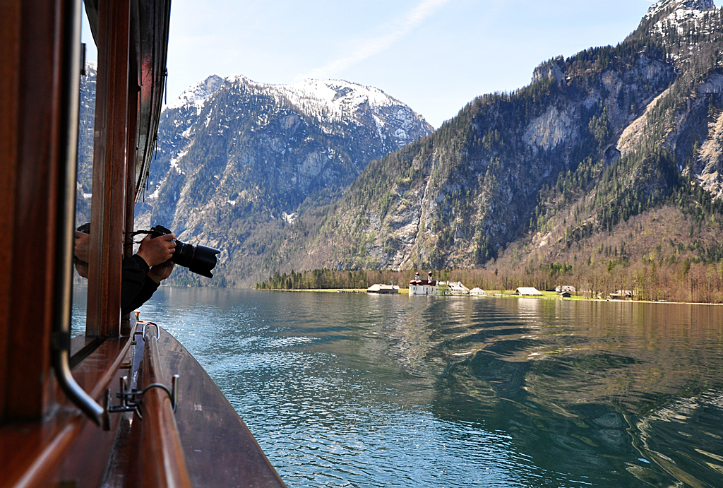 Asia-Fotograf mit Spiegelreflex  beim fotografieren der Bergwelt von Bord eines Knigssee-Schiffes. 26.04.2012