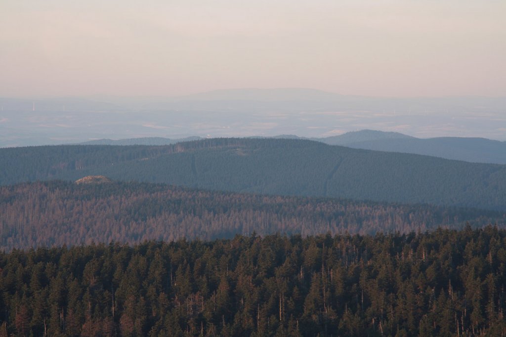 Auf dem Brocken im ersten Morgensonnenlicht; Blick am frhen Morgen des 28.08.2012 vom Gipfelrundweg Richtung Sdwesten ber den Bergrcken der Achtermannshhe, den Rehberg, Berge des Sdharzes bis zum ca. 85 km entfernten Basalttafelberg  Hoher Meiner  in Hessen (Bildmitte am Horizont).