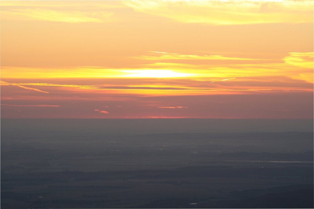 Auf dem Brocken vor Sonnenaufgang: die Sonne zeigt sich als zartes Glhen am Horizont; Blick am frhen Morgen des 28.08.2012 von der Treppe des Brockenhauses ber das nordstliche Harzvorland