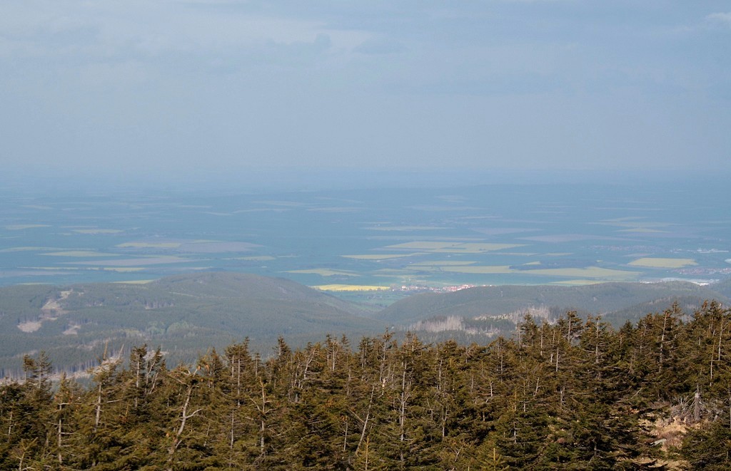 Brockenlandschaft aus Sonne und Wolken: Die Berge des nordstlichen Harzes, Darlingerode und ein Rapsfeld unter strahlendem Sonnenlicht, whrend das Harzvorland nrdlich davon noch unter dem dunklen Schatten einer mchtigen Wolkenwand liegt. Blick am Nachmittag des 27.04.2012 vom Gipfelrundweg des Brocken Richtung Nordosten.