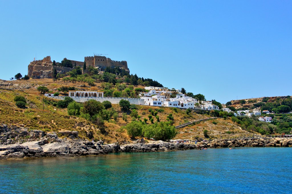 Die Bucht von Lindos auf Rhodos, der weien Stadt unter der Akropolis. Hier lassen sich  die Touristen die mit dem Schiff anreisen an Land bringen, um den 116m hohen Felsen auf dem sich die Reste der Akropolis befinden zu erklimmen. (15.06.2012)