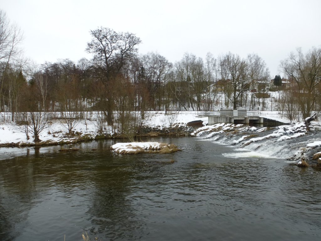 Die schsische Saale in Oberkotzau, zu sehen ist ein ca. 5 Meter hoher Damm sowie im Hintergrund Eisenbahnschienen, welche in Richtung Hof und in Richtung Bayreuth fhren. 
Fotografiert am 03.03.13.