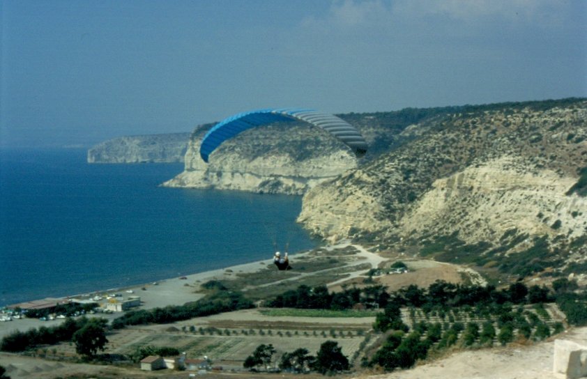 Ein schmeler Streifen Strand, dahinter etwas landwirtschaftlich genutzte Flche bevor die Landschaft karg ansteigt hinauf nach Kourion an der Westkste Zyperns. Hier nutzen Drachenflieger die Thermik zum gleiten. (November 1996)