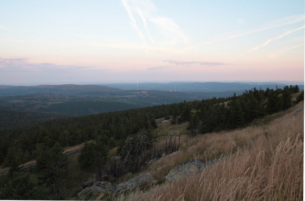 Erstes Morgenlicht auf dem Brocken; Blick am frhen Morgen des 13.08.2012 vom Gipfelrundweg Richtung Westen ber Torfhaus mit den beiden Riesenantennen, den Westharz bis zu den Weserberglandschaften am Horizont.