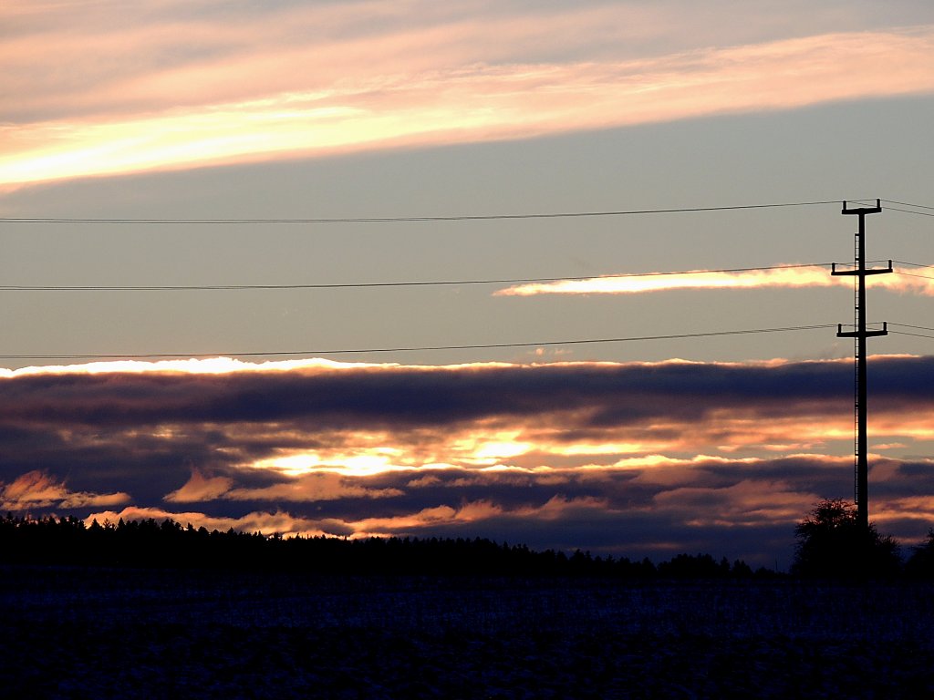 Sonnenuntergang wird von Starkstromleitung durchteilt; 130206