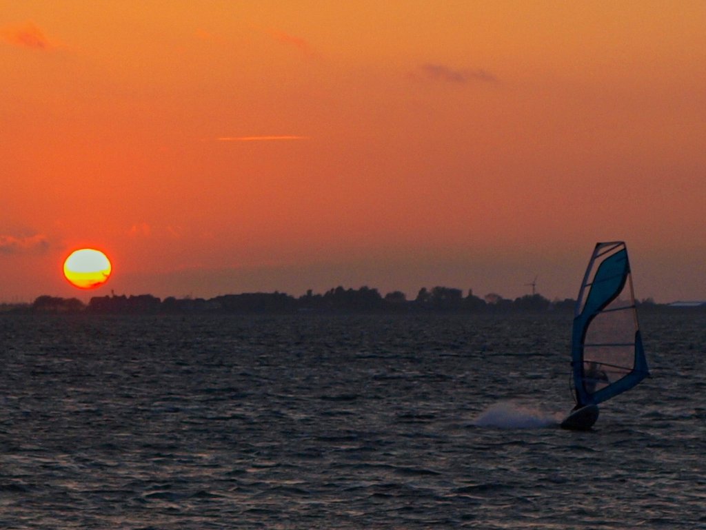 Surfer vor einem beeindruckendem Sonnenuntergang am Strand von Albertdorf auf Fehmarn im Mai 2010.