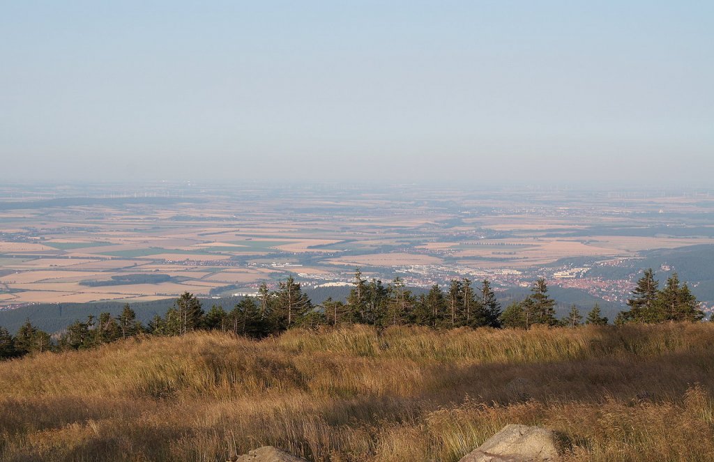 ber Wernigerode bis nach Magdeburg: Das nordstliche Harzvorland im Schein der Abendsonne. Blick am Abend des 19.08.2012 vom Brockengipfelplateau Richtung Nordosten ber Wernigerode und Halberstadt hinweg. In der linken Bildhlfte direkt unter dem Horizont blitzen und blinken Glasflchen moderner Gebude der ca. 80 km entfernten Magdeburger Skyline im Licht der Sonne.