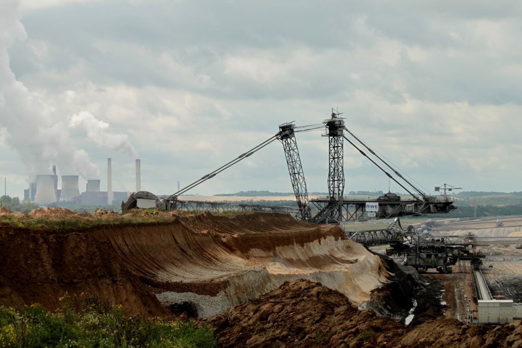 Unermdlich fressen sich die Braunkohlebagger durch die Landschaft um das Kraftwerk in Weisweiler (links im Bild) mit Kohle zu fttern. Auf dem Bild erkennt man sehr gut die einzelnen Bodenschichten, oben der fruchtbare hellbraune Lboden, darunter eine dunkelbraune Lehmschicht, heller Sand und dann schon die erste Braunkohleschicht Gesehen am 09.08.2011 im Rheinischen Braunkohlenrevier bei Inden. Dort gibt es einen Aussichtspunkt von dem man in das riesige Loch sehen kann in dem die Braunkohle abgebaut wird.