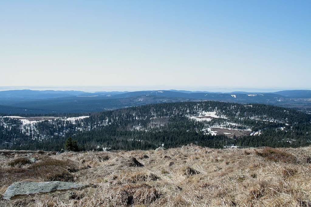 Vorfrhling auf dem Brocken: Blick um die Mittagszeit des 25.03.2012 vom Gipfelrundweg des Brocken Richtung Sdwesten ber den noch mit Schnee bedeckten Knigsberg, Berge des sdwestlichen Oberharz bis zum ca. 85 km entfernten Hohen Meiner in Hessen (in der Bildmitte am Horizont).