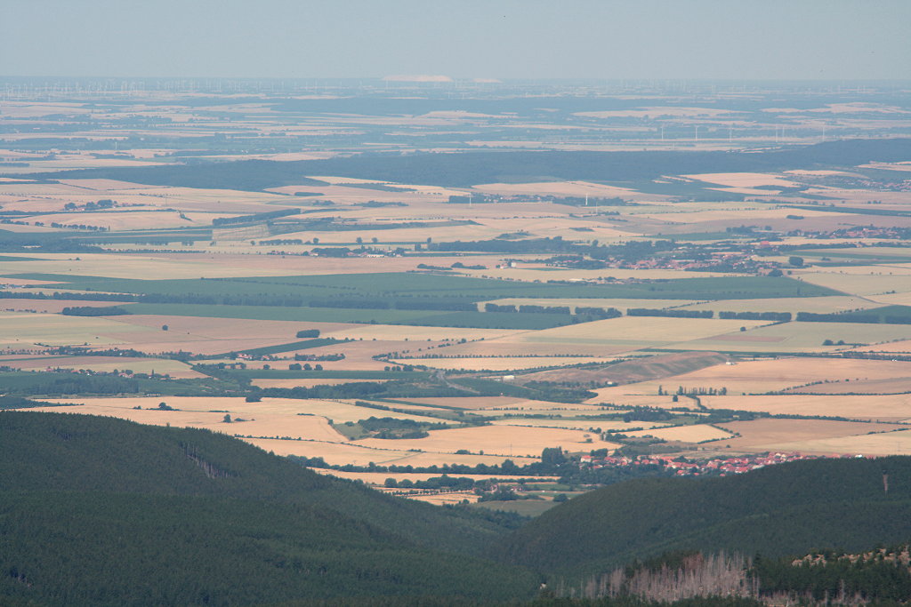 Weiter Blick vom Brocken am Nachmittag des 21.07.2013 Richtung Norden ber das Harzvorland bis weit in die Norddeutsche Tiefebene hinein: Unten Darlingerode am Harznordrand, darber im oberen Bilddrittel der langgestreckte Hhenzug Huy, darber  in der Bildmitte direkt unter dem Horizont der  Kalimandscharo , eine riesige Kalibergbau-Abraumhalde im Norden Sachsen-Anhalts, ca. 100 km entfernt...