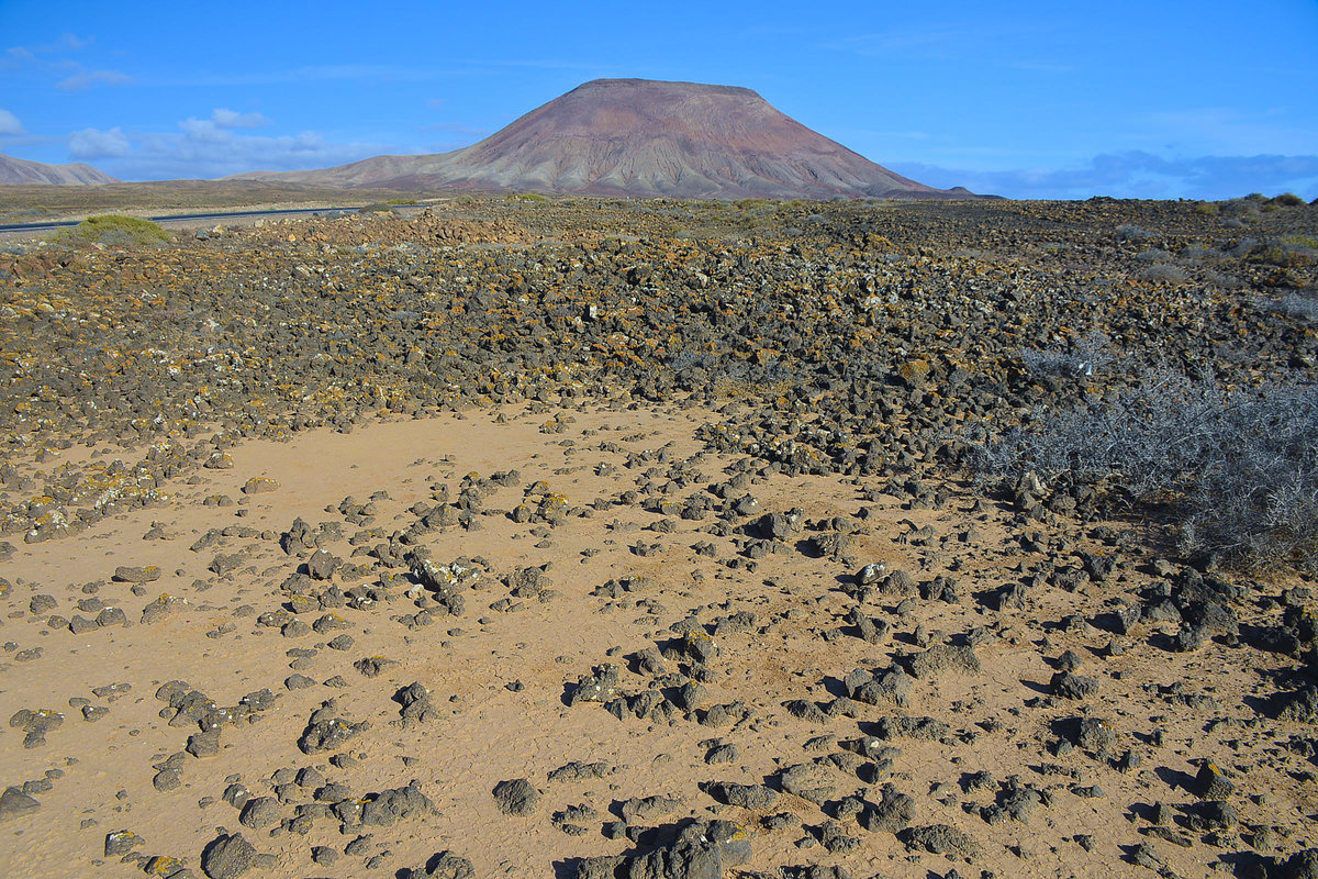  Will man die vulkanische Landschaft im südlichen Teil von Fuerteventura kennenlernen, so empfiehlt es sich, Wanderschuhe und –kleidung zu tragen, um auf den 300 Meter hohen Vulkan Montaña Roja aufzusteigen. Hat man seine Kamera dabei, kann man von hier aus wunderschöne Bilder von den Nachbarinseln Lanzarote und La Graciosa machen, die sich über dem Meer abzeichnen.
Aufnahme: 17. Oktober 2017.