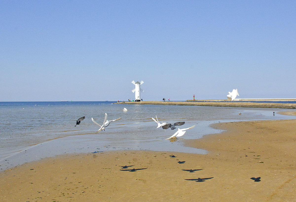 Am Strand vor Świnoujście (Swinemünde). Im Hintergrund ist Mühlenbake auf der Westmole zu sehen. Aufnahme: 6. Mai 2016.