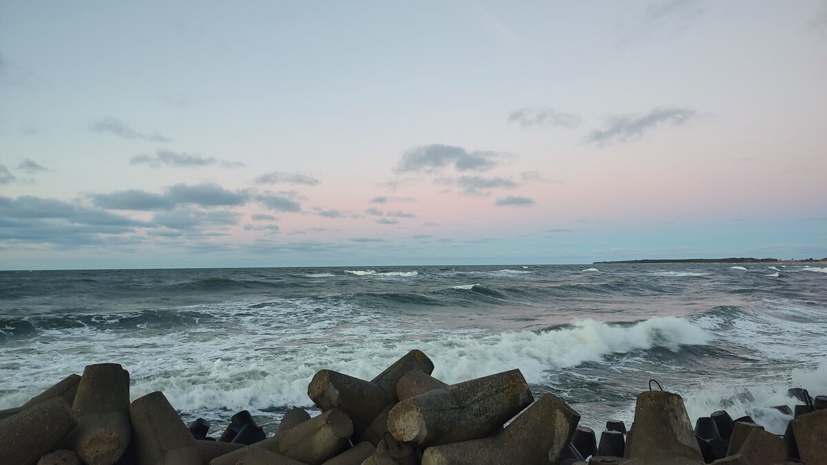 Blick auf die Ostsee in der polnischen Stadt Darłowo mit einem leicht orange-rosanem Himmel.
Aufgenommen am 28.12.2025 um 15:49 Uhr.