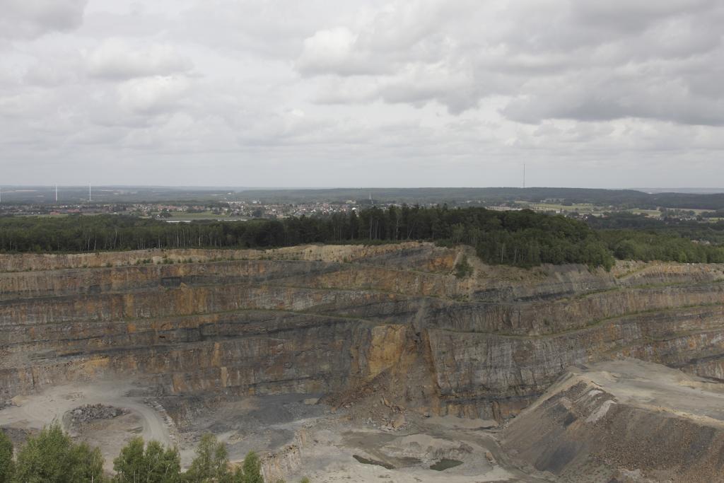 Blick auf die Steinbruchkante am Piesberg und darber hinweg vom Aussichtspunkt
aus in Richtung Norden nach Wallenhorst und Bramsche. In der Abbruchkante
sind kleine Kohleflze erkennbar.