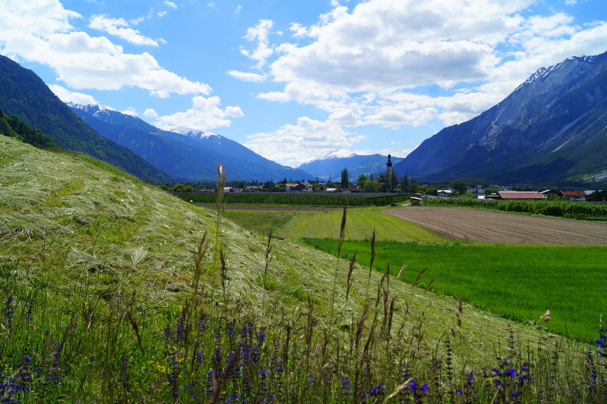 Blick über das Tiroler Oberinntal mit der Ortschaft Haiming. Bei den Obstbäumen im Hintergrund handelt es sich um Apfelplantagen. 01.06.2019.