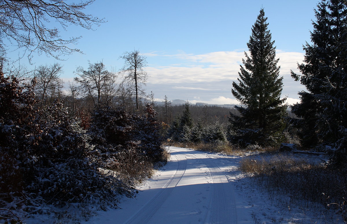 Blick über die winterliche Landschaft um die Hahnenkleer Waldstraße unter Schnee bis zu Bergreihen des Südharzes am Horizont; später Nachmittag des 21.11.2022... 