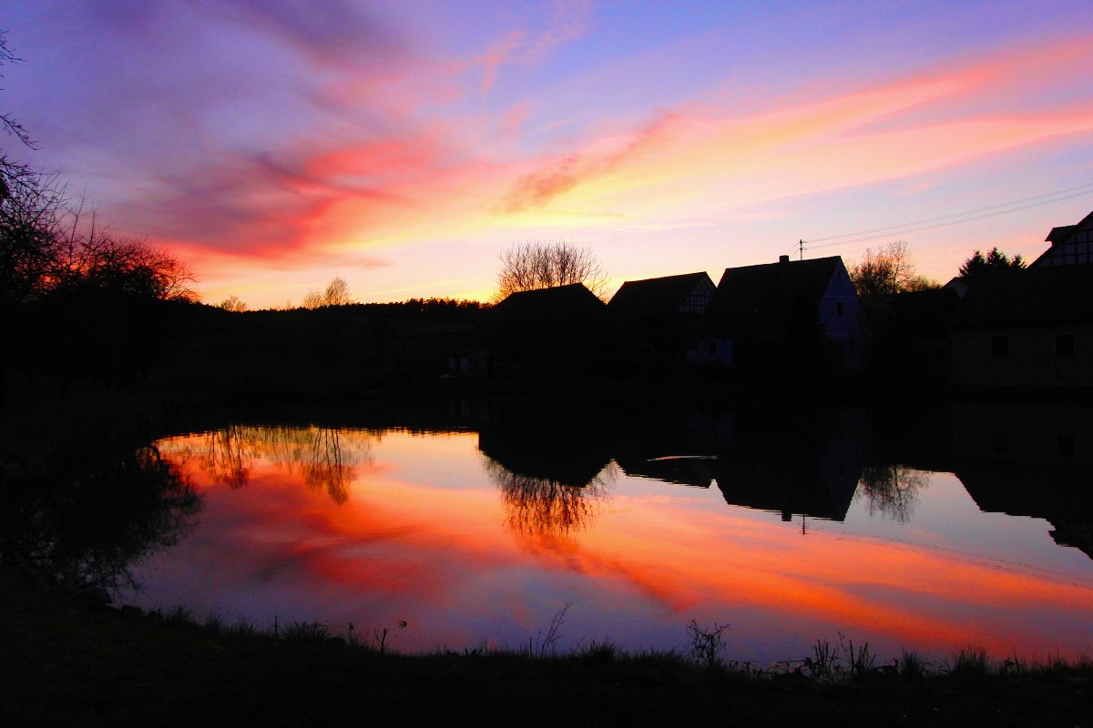 Der Abendhimmel spiegelt sich im Dorfweiher von Walchenfeld am Abend des 15.4.2015