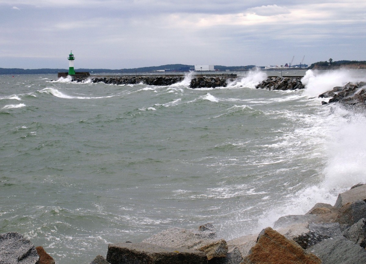 Der erste Herbststurm treibt die Ostsee gegen die Sassnitzer Hafenmole. Sie ist 1450 m lang und damit die längste Außenmole Europas; im Hintergrund die Hafenanlagen von Mukran. (24. September 2012)