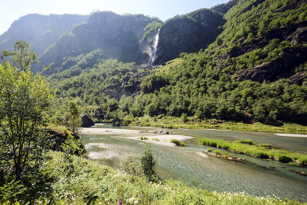 Der Fluss Flåmselv südlich von Flåm (Norwegen). Oben im Bild ist der Wasserfall von Treppen (466 Meter) zu sehen. Aufnahme: 13. Juli 2018.