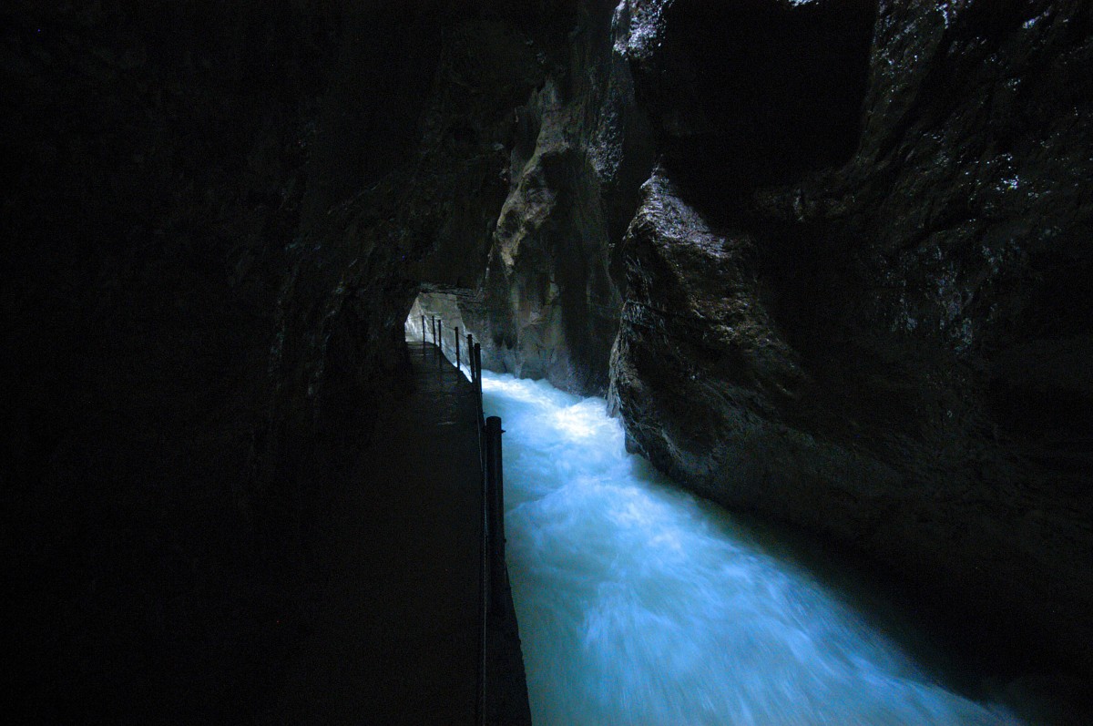 Der Gehweg in Paretnachklamm führt in den Fels gehauene Weg direkt am Wasser entlang, die seitlichen Felswände steigen senkrecht bis überhängend in die Höhe und lassen nur einen kleinen Spalt frei, durch den Licht in die Schlucht fällt. Aufnahme: Jui 2008.