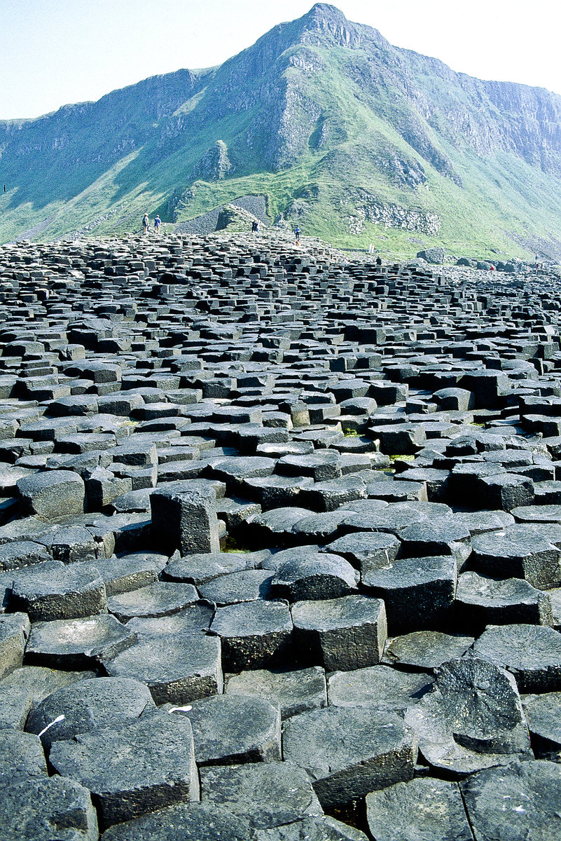 Der Giant’s Causeway befindet sich an der nördlichen Küste des Countys Antrim in Nordirland.  Er besteht aus etwa 40.000 gleichmäßig geformten Basaltsäulen, die ein Alter von etwa 60 Millionen Jahren aufweisen. Etwa die Hälfte der Säulen hat einen sechseckigen Querschnitt, es treten jedoch auch solche mit vier, fünf, sieben oder acht Ecken auf. Bild vom Dia. Aufnahme: Juni 1991.