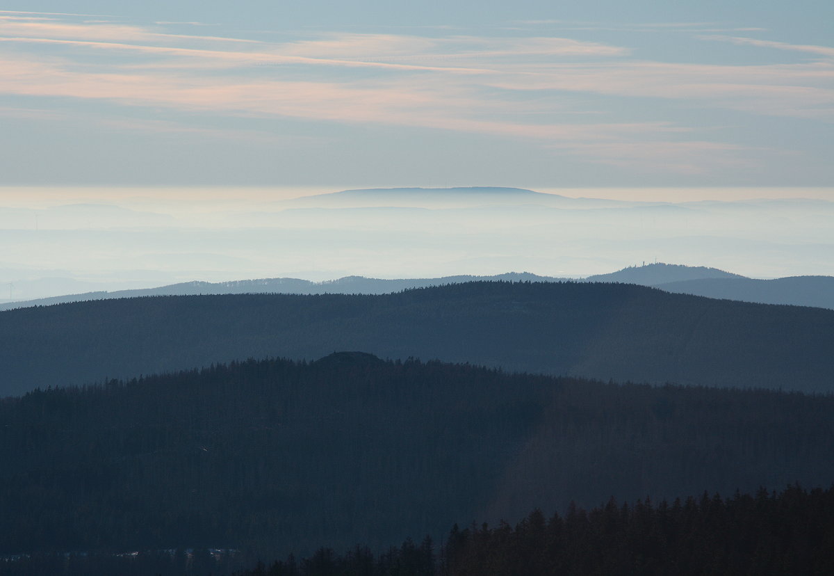 Der  Hohe Meißner in Hessen, ein Basalttafelberg, auf dem nach alter Sage Frau Holle leben und wirken soll, ragt ca. 85 km entfernt aus einem Nebelmeer; von unten nach oben: die Achtermannshöhe mit ihrem Felsgipfel, der Rehberg und rechts darüber, direkt vor dem Nebelmeer der Große Knollen mit seinem Aussichtsturm. Blick am Abend des 05.212.2016 vom Brocken... 