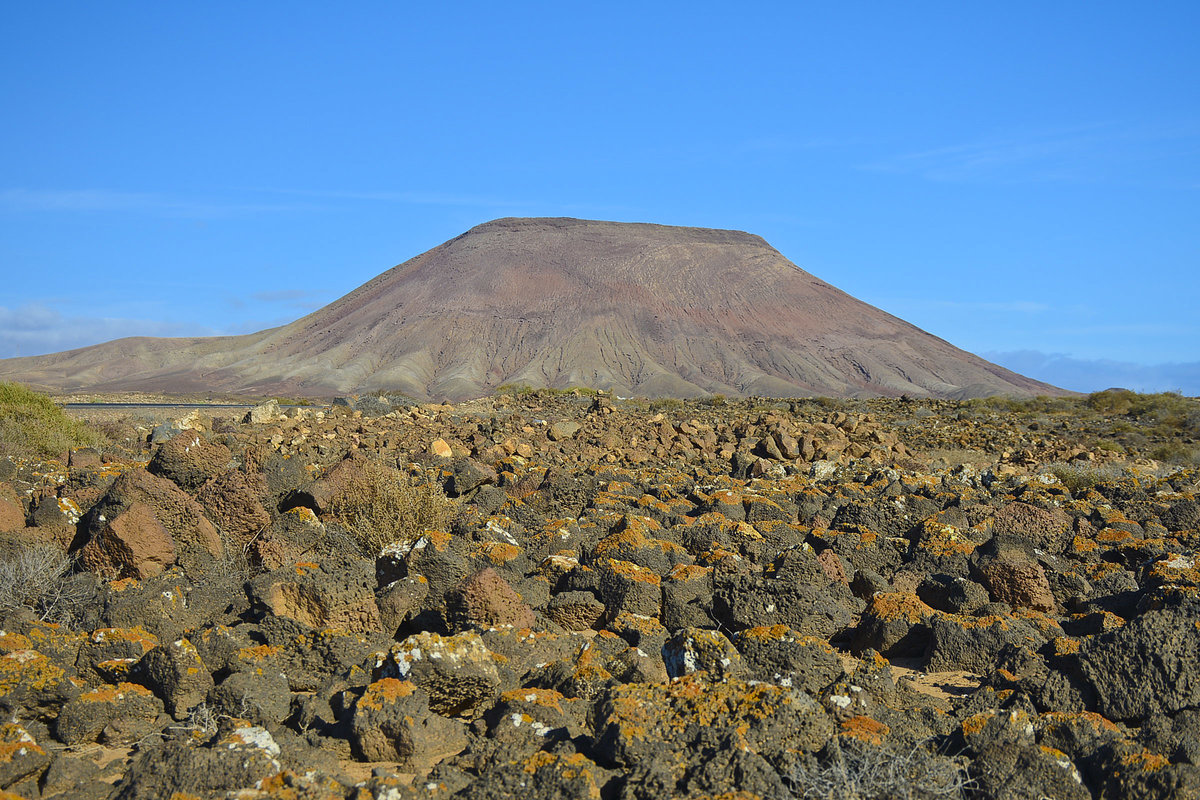 Der Vulkan Montaña Roja befindet sich kurz vor Wanderdüne El Cable südlich von Corralejo auf der Insel Fuerteventura - Spanien.
Aufnahme: 17. Oktober 2017.