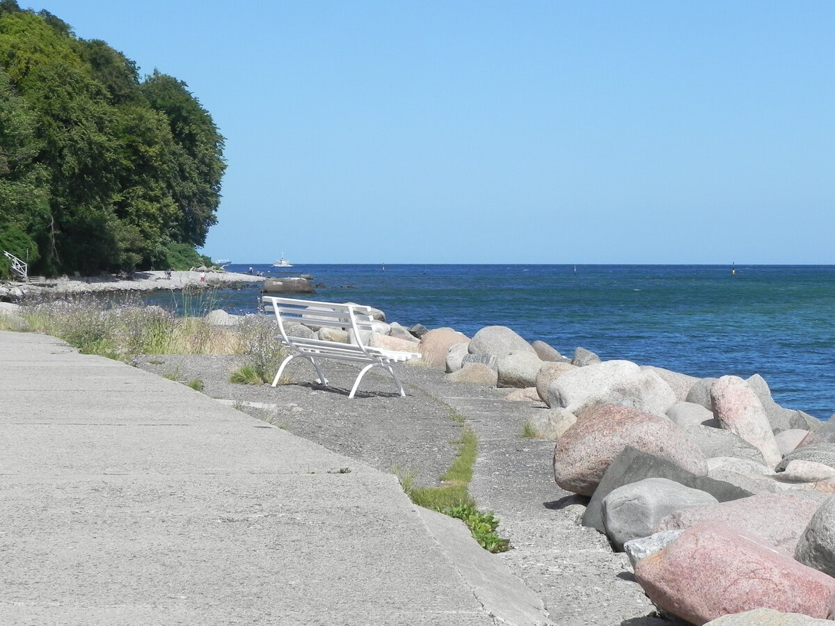 Die Bank lädt zum Verweilen ein. Auf der Strandpromenade der Hafenstadt Sassnitz am 03.07.25.