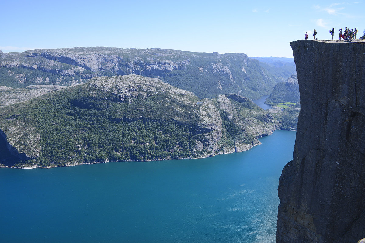 Die Felsformation Prekestolen  entstand durch Frostsprengung vor zirka 10.000 Jahren, als die Kanten des Gletschers bis oberhalb des Felsens reichten. Die Größe des Felsplateaus beträgt zirka 25 mal 25 Meter. Die Felskante fällt 604 Meter senkrecht in den fast 40 Kilometer langen Fjord ab.
Aufnahme: 2. Juli 2018.