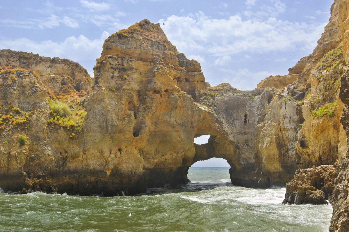 Die Ponta da Piedade besteht aus gelbem Fels. Durch die durch das Meer über Jahrtausende ausgewaschenen Höhlen und Grotten fließt das Meerwasser. Aufnahme: Juli 2010.