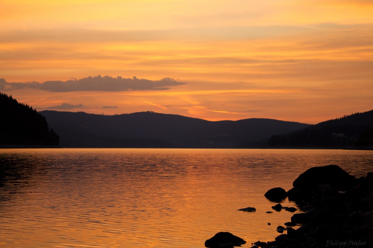 Die Sonne ist gerade hinter dem Feldberg untergegangen und taucht den Schluchsee in ihr goldenes Licht. So gesehen am 18.07.2015 in Seebrugg.