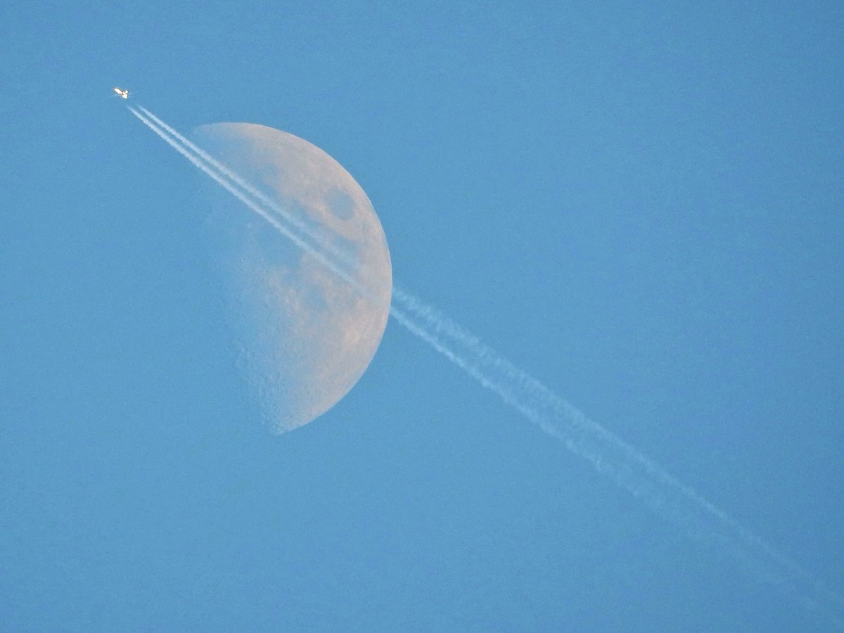 Ein Flugzeug fliegt am zunehmenden Mond vorbei, am 17. September 2018 um 18:20 Uhr